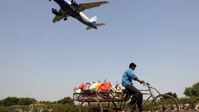 An IndiGo Airlines aircraft prepares to land as a man rides his rickshaw in Ahmedabad. Amit Dave / Reuters