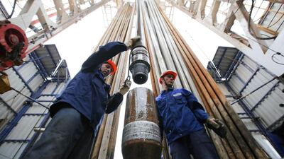 Workers secure drilling pipe sections on an oil drilling tower operated by Tatneft OAO near Almetyevsk, Russia. Andrey Rudakov / Bloomberg
