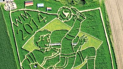 An aerial view taken on July 15, 2014 shows a field in football-design in Uttig, southern Germany. A labyrinth carved in the field shows a footballer making a bicycle kick on the flag of the 2014 Football World Cup host country Brazil as well as the flags of the winning nations (left to right) Germany (1st), Argentina (2nd) and The Netherlands (3rd). The field was created by farmers Uli and Corinne Ernst and their team since the sowing in April 2014 and consists of hemp, corn, rapeseed, sunflowers and common mallow. The giant greeting card to celebrate Germany’s Fifa World Cup title measures 18,000 square meters, has an approximately three kilometres long labyrinth and is open for visitors from July 17 to September 28, 2014. Peter Kneffel / AFP photo