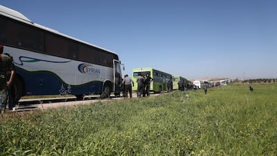 A convoy transporting Syrian civilians and rebel fighters evacuated from Eastern Ghouta waits in a government-held area prior to entering the village of Qalaat al-Madiq, some 45 kilometres northwest of the central city of Hama, on March 26, 2018, as evacuations from the opposition enclave continued following a deal that was announced earlier in the week. Abdulmonam Eassa / AFP