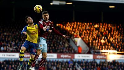 Aaron Cresswell of West Ham jumps for the ball under pressure from Santi Cazorla of Arsenal. Julian Finney / Getty Images