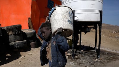 A displaced Yemeni boy carries a UNHCR bucket at a camp for Internally Displaced Persons (IDPs) on the outskirts of Sana'a, Yemen. EPA