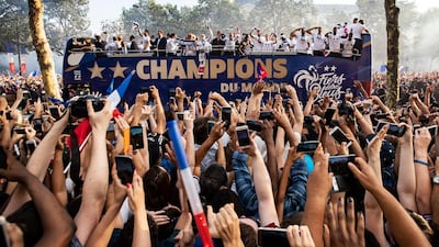 French supporters greet the France's national soccer team players as they stand on the rooftop of a bus during a parade down the Champs-Elysee avenue in Paris, France, 16 July 2018. France won 4-2 the FIFA World Cup 2018 final against Croatia in Moscow, on 15 July. EPA