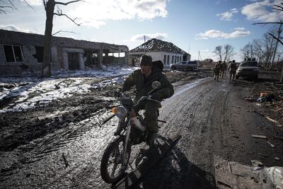 A Russian soldier rides a motorbike in a Ukraine village. AFP