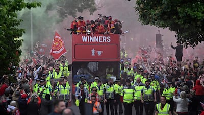 Reds players wave from an open-top bus during a parade through the streets of Liverpool. AFP