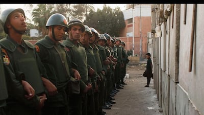 A boy leans against a newly built barrier in front of soldiers standing guard outside the Egyptian presidential palace in Cairo. Asmaa Waguih / Reuters