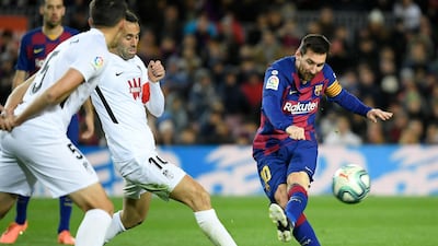 Messi shoots beside Granada's Spanish midfielder Antonio Puertas. AFP