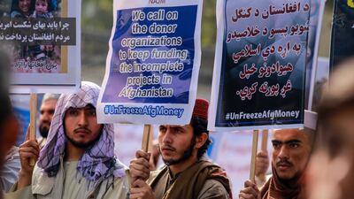 Afghans in Kabul hold banners and placards as they demand the unfreezing of Afghan assets and money the US seized after the Taliban takeover. EPA