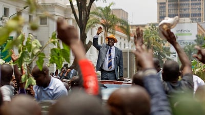 Opposition leader Raila Odinga waves to a crowd of supporters as he leaves the Supreme Court in Nairobi