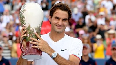Roger Federer celebrates with the Western and Southern Open winner's trophy