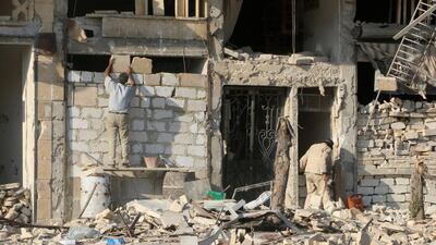 A man rebuilds a wall of a damaged building in the rebel-held Al Katerji district of Aleppo city in Syria on August 13, 2016. Abdalrhman Ismail / Reuters