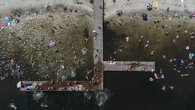 People swim and sunbathe at Lake Piaseczno, Poland, where officials have issued extreme heat warnings for most of the country. EPA