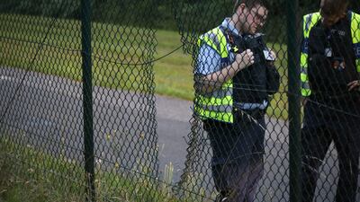 Police officers stand next to a hole in the fence at Cologne/Bonn Airport, Germany, Wednesday July 24, 2024. Climate activists have caused an interruption to air traffic at Cologne/Bonn Airport. (dpa via AP)