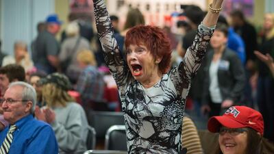 Robin Bernik, who recently moved to Oregon from Florida, watches as her home state is called for Republican presidential candidate Donald Trump at a Republican watch party at the Vet’s Club in in Eugene, Oregon. Brian Davies / The Register-Guard via AP