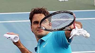 Federer throws his arm band to the crowd at the Zayed Sports City in Abu Dhabi.