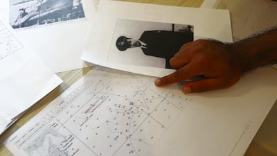 Mr Iqbal points to a map of the seabed where the submarine lies. A photo of one of the dead Italians, Pietro Venuti, is also on the table. Pawan Singh / The National