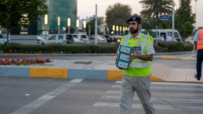 Red Crescent volunteers and Abu Dhabi Police distribute food to motorists during iftar. Victor Besa / The National