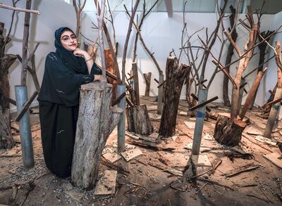 SEAF Cohort 5 artist Alya Alhosani with a forest made of objects found across Abu Dhabi