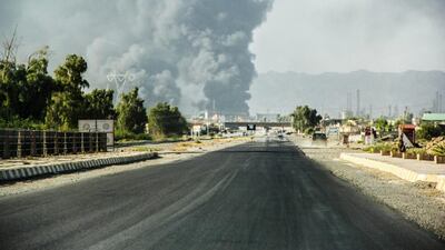 Smoke rises from an oil refinery near Beiji town after an attack by Islamic militants in July. Iraqi forces saiod they had regained control of Beiji on November 14, 2014. AP Photo / July 31, 2014