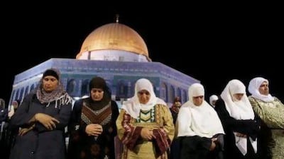 Palestinian Muslim worshippers pray outside the Dome of the Rock in the Al Aqsa Mosque compound in Jerusalem's Old City.