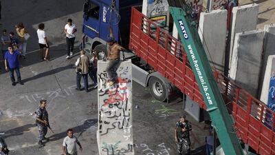 A crane removes part of a concrete barrier in front of the prime minister’s offices in Beirut on August 25, 2015. Hassan Ammar / AP Photo