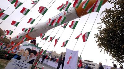 A boy holding a placard poses for camera in front of a model of Simorgh satellite-carrier rocket. Reuters