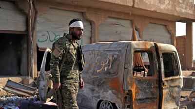 A fighter from the Syrian Democratic Forces stands guard in the front line village of Baghouz in the countryside of the eastern Syrian Deir Ezzor province. AFP / Delil Soulieman