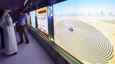 Visitors look at screens displaying images of the Mohammed bin Rashid Al Maktoum Solar Park on March 20, 2017, at the solar plant in Dubai. AFP