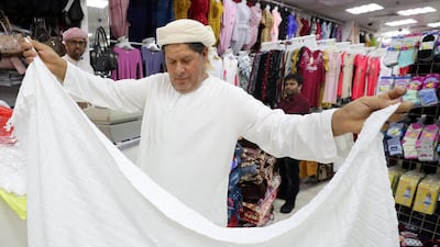 Mohammed Barakat 45, from Egypt, shows off a Ihram to be worn during Hajj at Salmin Trading Shops in Abu Dhabi. All Photos by Chris Whiteoak / The National