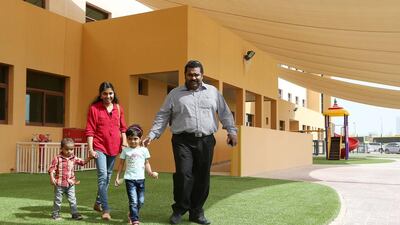 Ashiq and Shemy Habeeb show their daughter Fathima around the grounds of her new school, Credence High School, with their son Habeeb Ashiq. Pawan Singh / The National