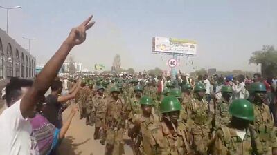Demonstrators salute soldiers during a protest in Khartoum, Sudan April 10, 2019 in this still image taken from a video obtained from social media. Twitter user @THAWRAGYSD via REUTERS
