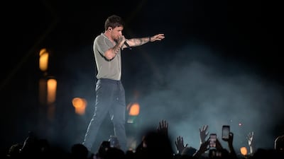 Fans wave to Liam Payne as he performs. AP Photo
