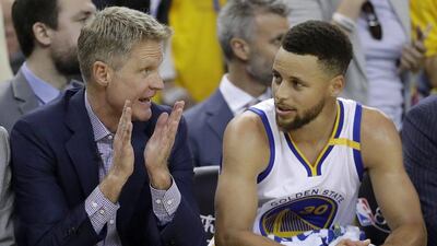 Golden State Warriors head coach Steve Kerr, left, talks with guard Stephen Curry during the second half of Game 2 of basketball's NBA Finals against the Cleveland Cavaliers in Oakland, Califorbia, Sunday, June 4, 2017. Marcio Jose Sanchez / AP Photo