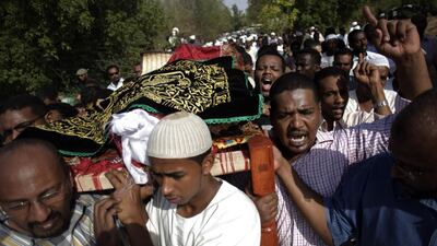 Sudanese men carry the body of Salah Sanhory, 29, who was shot and killed last Friday by security forces, during his funeral at which about 2,000 attended, in Khartoum on the weekend. Khalil Hamra / AP Photo