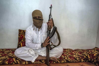 Taliban commander Qary Khalid poses with his gun in his living room. He joined the Afghan insurgents in his early teens after being educated in a madrassa in Peshawar, Pakistan. Stefanie Glinski for The National