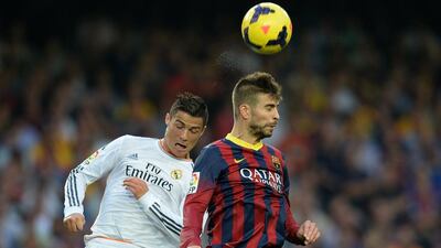 Real Madrid’s Portuguese forward Cristiano Ronaldo challenges Barcelona’s Gerard Pique during el clasico ar Camp Nou on Saturday. Lluis Gene / AFP