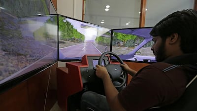 Jasim Izaz gets his hands on the wheel of the driving simulator at Emirates Driving Institute. Jeffrey E Biteng / The National