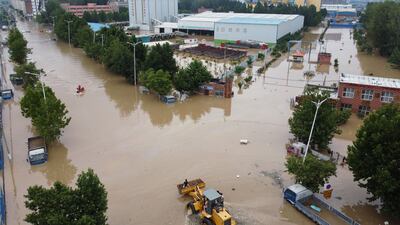 An aerial view shows rescue workers evacuating residents on a flooded road following heavy rainfall in Zhengzhou, Henan province, China.
