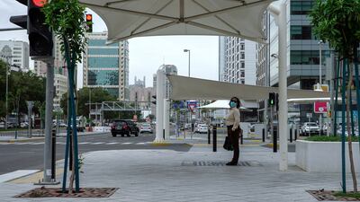 A pedestrian waiting to cross the road, Al Ain Street, Abu Dhabi Mall area. Victor Besa / The National Section