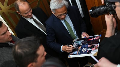 Nvidia Chief executive Jensen Huang signs an autograph while arriving for a meeting with a Senate committee in Washington.