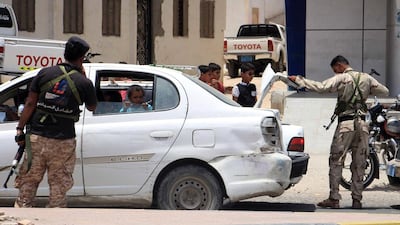 Yemeni security forces inspect vehicles at a checkpoint in Mukalla on July 19, 2016, a day after 11 people were killed in twin bombings claimed by Al Qaeda. With the extremists driven out of the city in south-western Yemen, Omani authorities are concerned that they might try to cross the border. Abduljabbar Bajubair / AFP