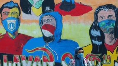 A woman walks past a mural promoting awareness of the coronavirus disease outbreak in Jakarta, Indonesia. Rueters