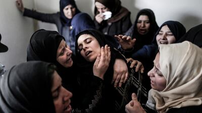 Mourners console the mother (C) of 15-year-old Palestinian teenager Azzam Oweida during his funeral in Khan Younis in the southern Gaza Strip on April 28, 2018, as he succumbed to his wounds a day after he was shot by Israeli forces in clashes along the Gaza border. Mahmud Hams / AFP
