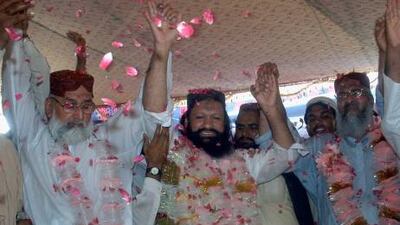 Malik Ishaq, centre, a leader of the Lashkar-e Jhangvi, and his colleagues respond to their supporters who greeted him with rose petals when he arrived home from prison in July.