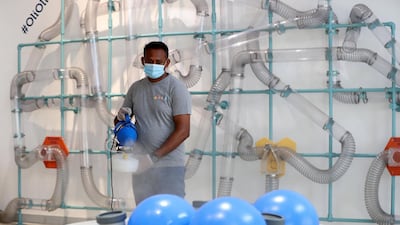 A staff member sterilises the facilities at OliOli. Chris Whiteoak / The National