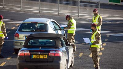 Members of the military check the paperwork of drivers. Bloomberg