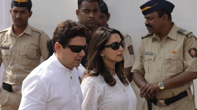 Bollywood actress Madhuri Dixit, right, and her husband Sriram Nene pay their respects. Divyakant Solanki / EPA