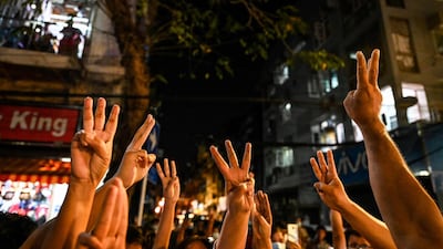 People give a three-finger salute following calls to hold protests after Myanmar's military charged ousted leader Aung San Suu Kyi with importing walkie-talkies. AFP