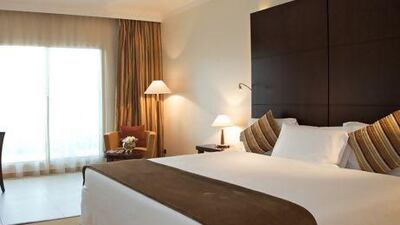 Rooms offer tasteful decor and a luxurious bed. Courtesy of Mafraq Hotel