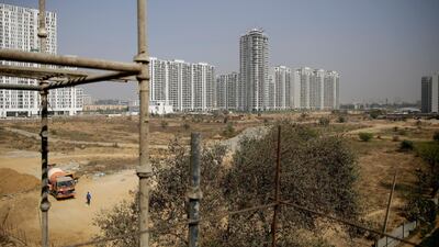 An Indian worker walks near a concrete mixer truck at a proposed site for the Trump Towers in Gurgaon, a suburb of New Delhi, India. Altaf Qadri / AP Photo